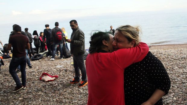 Family members hug moments after arriving on the island of Lesbos in a raft from Turkey with other Iraqi and Syrian refugees on Wednesday. Dozens of rafts are still making the journey daily.