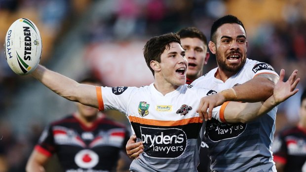Mitchell Moses of the Tigers celebrates with teammate Dene Halatau after scoring a try against the Warriors.