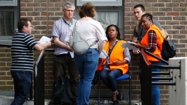 Council workers talk to residents outside Dorney block in Camden which was evacuated on Friday, deemed unsafe.