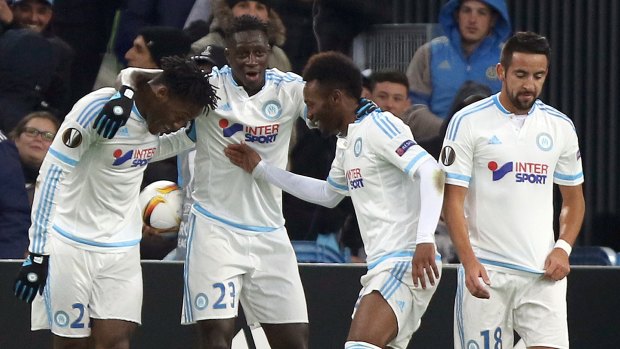 Marseille players celebrate a goal in the Europa League. But in the French domestic league, a ban applies to away fans.
