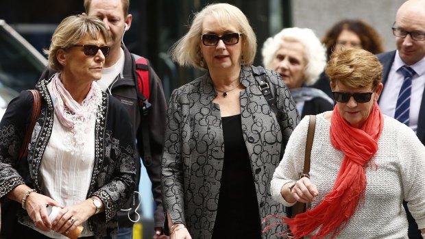 Liz Noble, left, the mother of Rozelle store explosion victim Chris Noble, arrives at court with supporters on Friday.