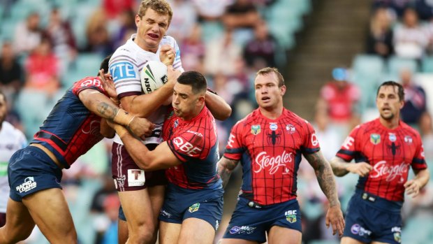 Squeezed: Tom Trbojevic is held up by the Roosters defence.