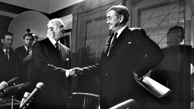 Prime Minister John Gorton shakes hands with William McMahon during a press conference in Canberra on November 7, 1969. 