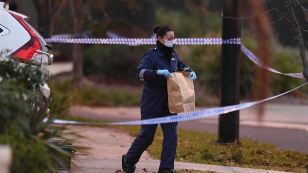 A forensics officer carries evidence from the Deer Park home, the day after Mr Vuong's body was found.