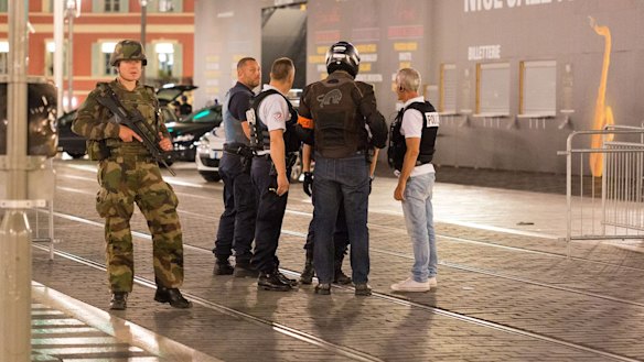 Police officers and a soldier stand by the sealed-off area where the attack took place.
