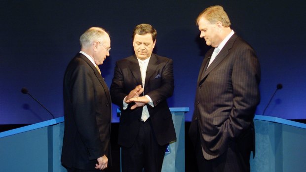 John Howard and Kim Beazley watch moderator Ray Martin flip a coin at the 2001 debate.