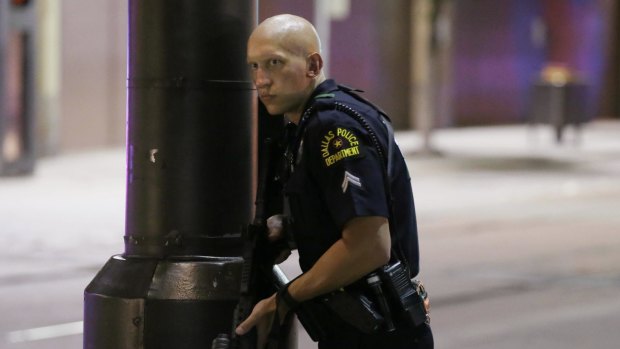 A Dallas policeman keeps watch on a street in downtown Dallas.