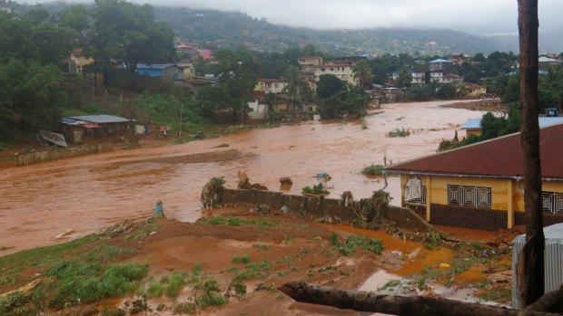 A torrent of water flows through a flooded neighbourhood in Regent, east of Freetown, Sierra Leone, on Monday.
