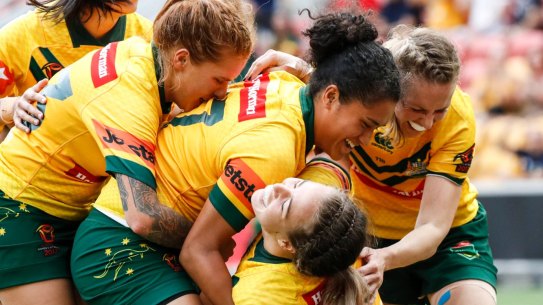 Mobbed: Isabelle Kelly celebrates a try with teammates.
