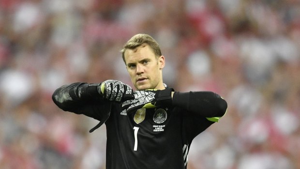 No sweat: Germany goalkeeper Manuel Neuer takes off his gloves after a very quiet game, in which he wasn't drawn into a save, against Poland at the Stade de France.