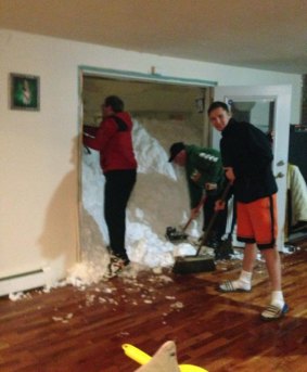 Mark Hazard, his son Jason and Bryan Juda shovel out the snow from their Cheektowaga, New York, home. 