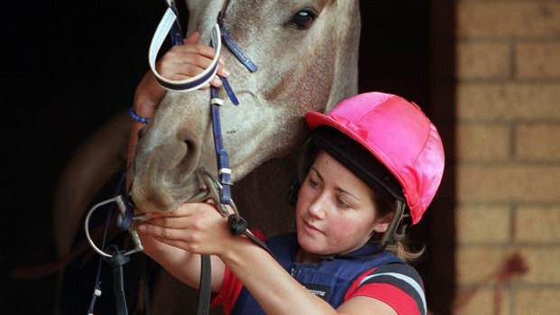 Michelle Payne putting the bridle on her horse in 2001.