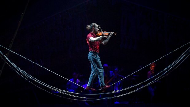 Alex Weibel Weibel plays violin while performing on the slack-rope.