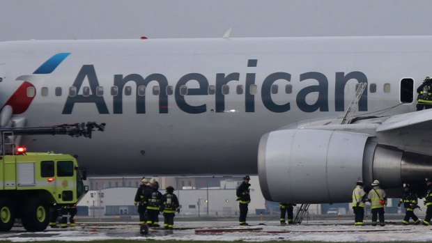Chicago firefighters investigate the fire damaged American Airlines jet.