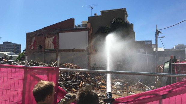 Firefighters dampening down building waste where Carlton's Corkman Irish Pub stood for 159 years.