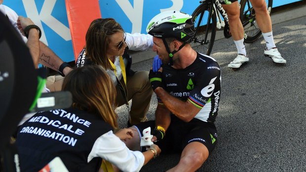 Mark Cavendish is treated by medics after he crashed during the sprint of the fourth stage of the Tour de France.