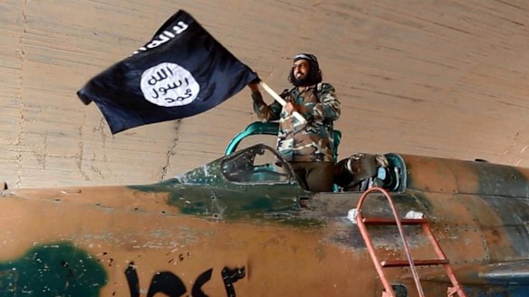 An Islamic State fighter in a captured government fighter jet in Raqqa, Syria, last year.