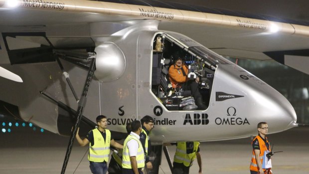 Pilot Andre Borschberg sits at the cockpit of Solar Impulse 2 after it landed in the Omani capital.