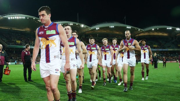 Lions leave the field lead by captain Tom Rockliff after the round-20 thrashing by Adelaide.