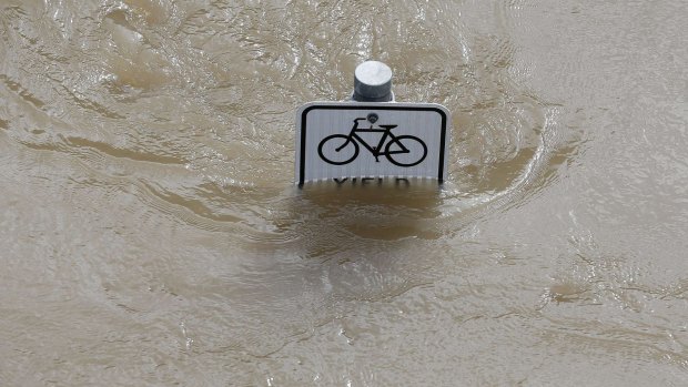 Water is seen at the top of a sign along a bike path near Memorial Drive in Houston.