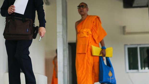 A monk follows an officer inspecting a medical center on the Wat Dhammakaya temple.