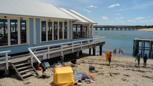 Holidaymakers enjoy the beach and a snack at Barwon Heads.