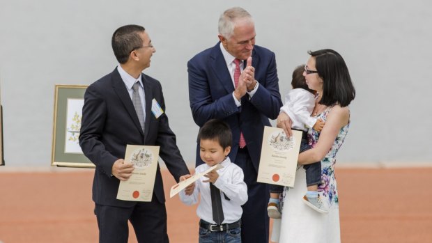 Prime Minister Malcolm Turnbull presents the Nguyen family with their citizenship certificates 
