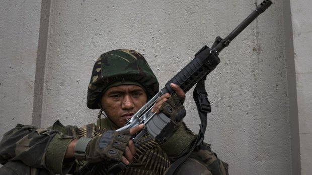 Soldiers take positions while evading sniper fire as they try to clear the city of Marawi of armed militants one street at a time.