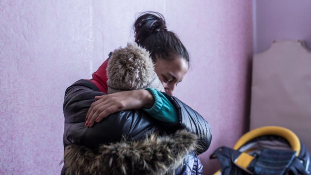 Two women share a hug at a distribution point for humanitarian aid at the local House of Culture in Myronivskyi, Ukraine.