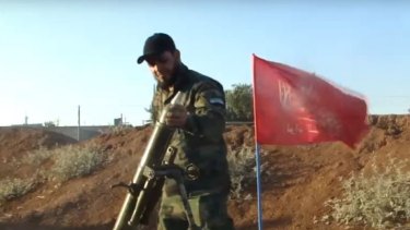 A Turkmen fighter loads a mortar while fighting Syrian government forces.