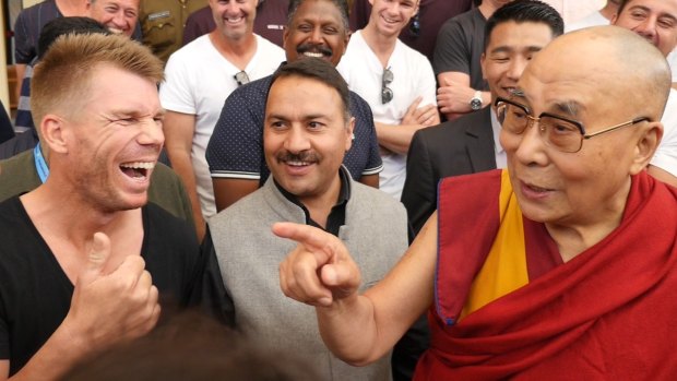 Light banter: The Dalai Lama appears to share a joke with Dave Warner.