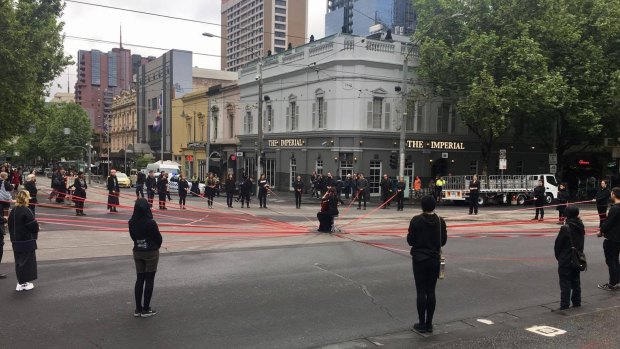 Refugee supporters block Spring Street intersection in Melbourne.