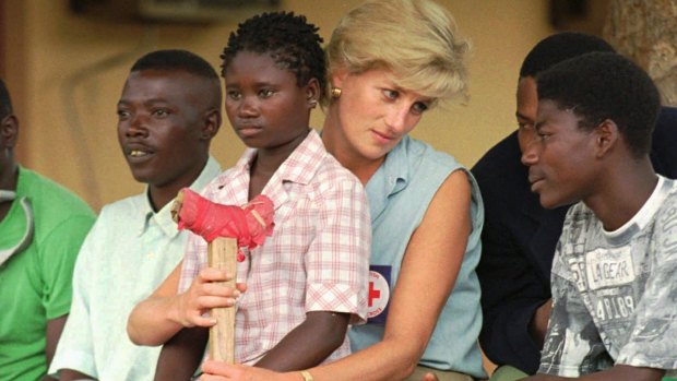 Diana talks to amputees who lost limbs to land mines, in Angola in 1997.