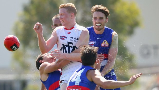 Crunch time:  Clayton Oliver rids possession as Bulldog defenders apply pressure.