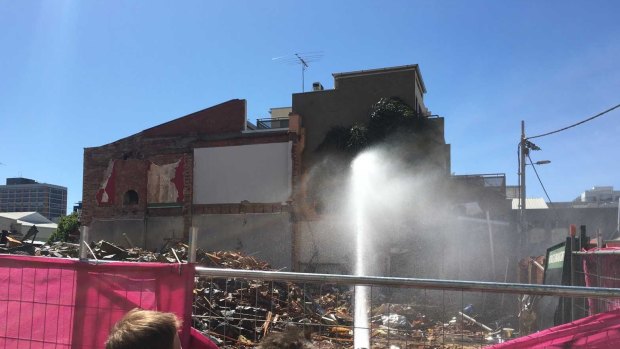 Firefighters dampening down building waste where Carlton's Corkman Irish Pub stood for 159 years.