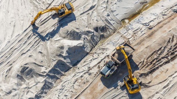Bulldozers and cranes will now be used to shape the 6 million cubic metres of sand which has been allowed to compress on the Brisbane Airport site before a new 