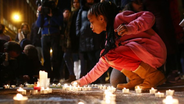 A young girl lights a candle at the Place de la Bourse following the attacks in Brussels.