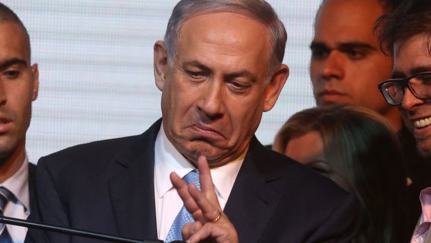 Israeli Prime Minister Benjamin Netanyahu gestures to  supporters as he reacts to exit poll figures in Israel's parliamentary elections.