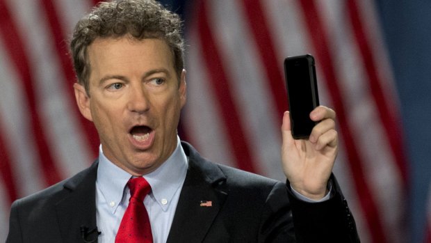 US Presidential candidate Senator Rand Paul holds up his phone while speaking about his opposition to NSA spying. 