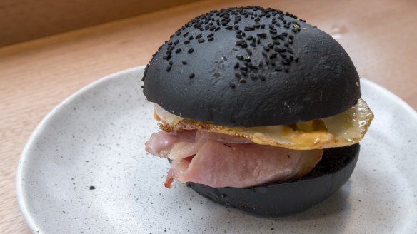 Free-range bacon, fried egg and sriracha mayonnaise in a squid ink bun.