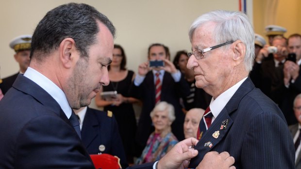 Denis Kelly receives the Legion d'Honneur from ambassador Christophe Lecourtier.