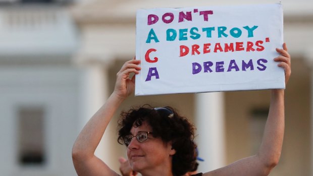 Woman holds up a sign during a rally supporting Deferred Action for Childhood Arrivals, or DACA, outside the White House.