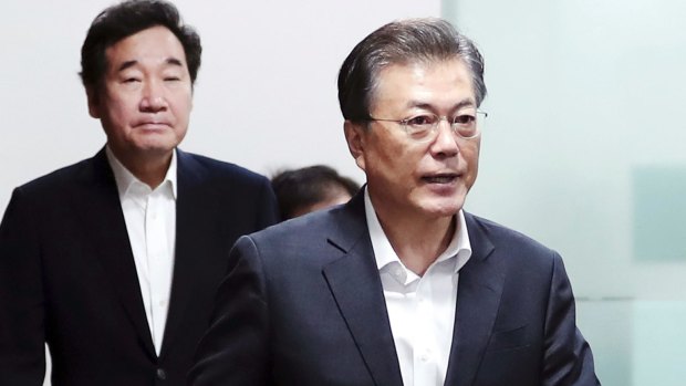 South Korean President Moon Jae-in, right, arrives to preside over a meeting of his National Security Council on Friday.