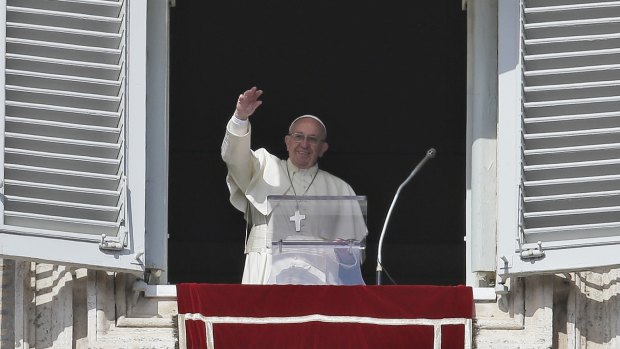 Pope Francis waves to crowds in St Peter's Square. Cardinal Pell says he has the pontiff's backing.