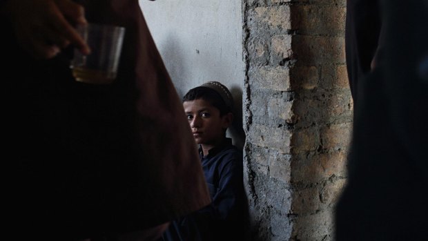 A boy inside one of the incomplete houses in Amanullah Khan town in Rodat District, Afghanistan.