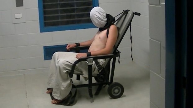 Dylan Voller is hooded and strapped to a restraining chair in the footage aired on Four Corners.