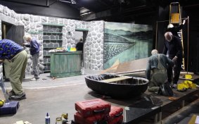 Members of a community theatre group build a set.