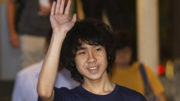 Amos Yee waves as he leaves court in Singapore.