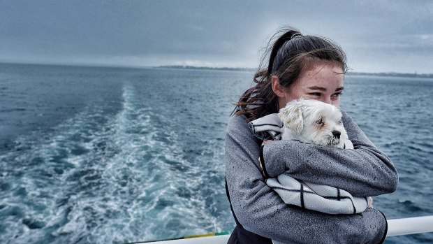 Olivia snuggles with dog Joey aboard the Sorrento-Queenscliff ferry on Saturday.
