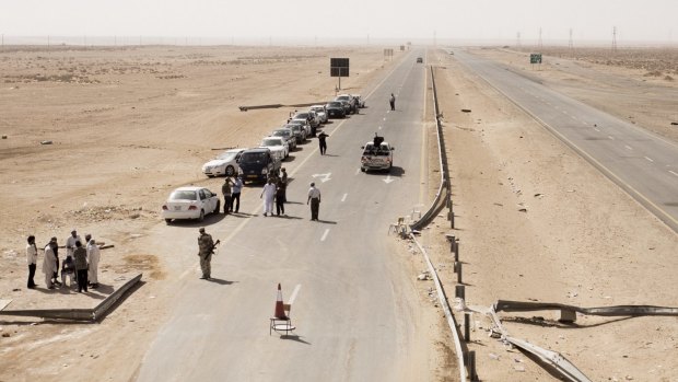 A convoy of vehicles carrying families fleeing Sirte in 2011.

